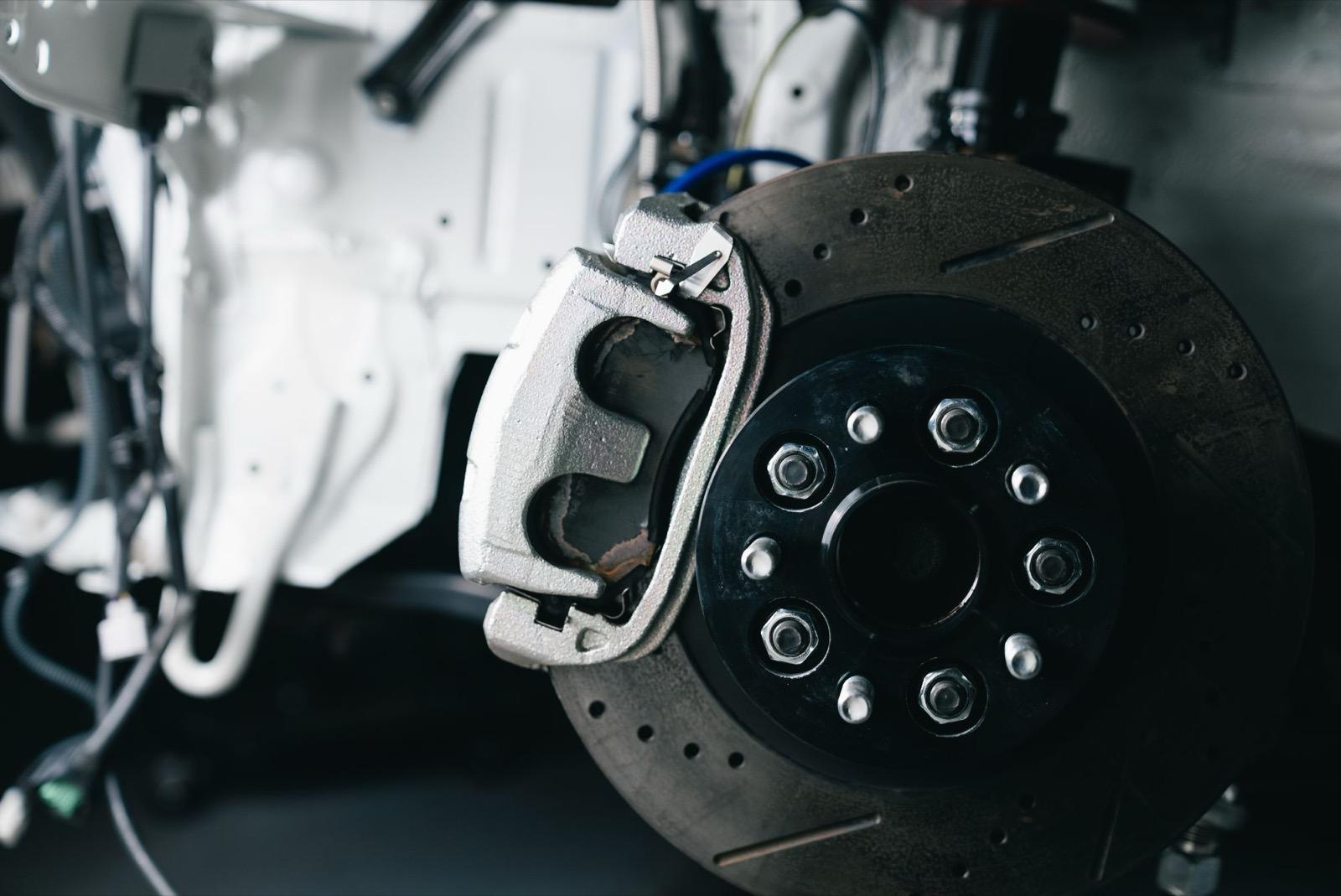 Close-up of a car brake disc and caliper during a brake inspection